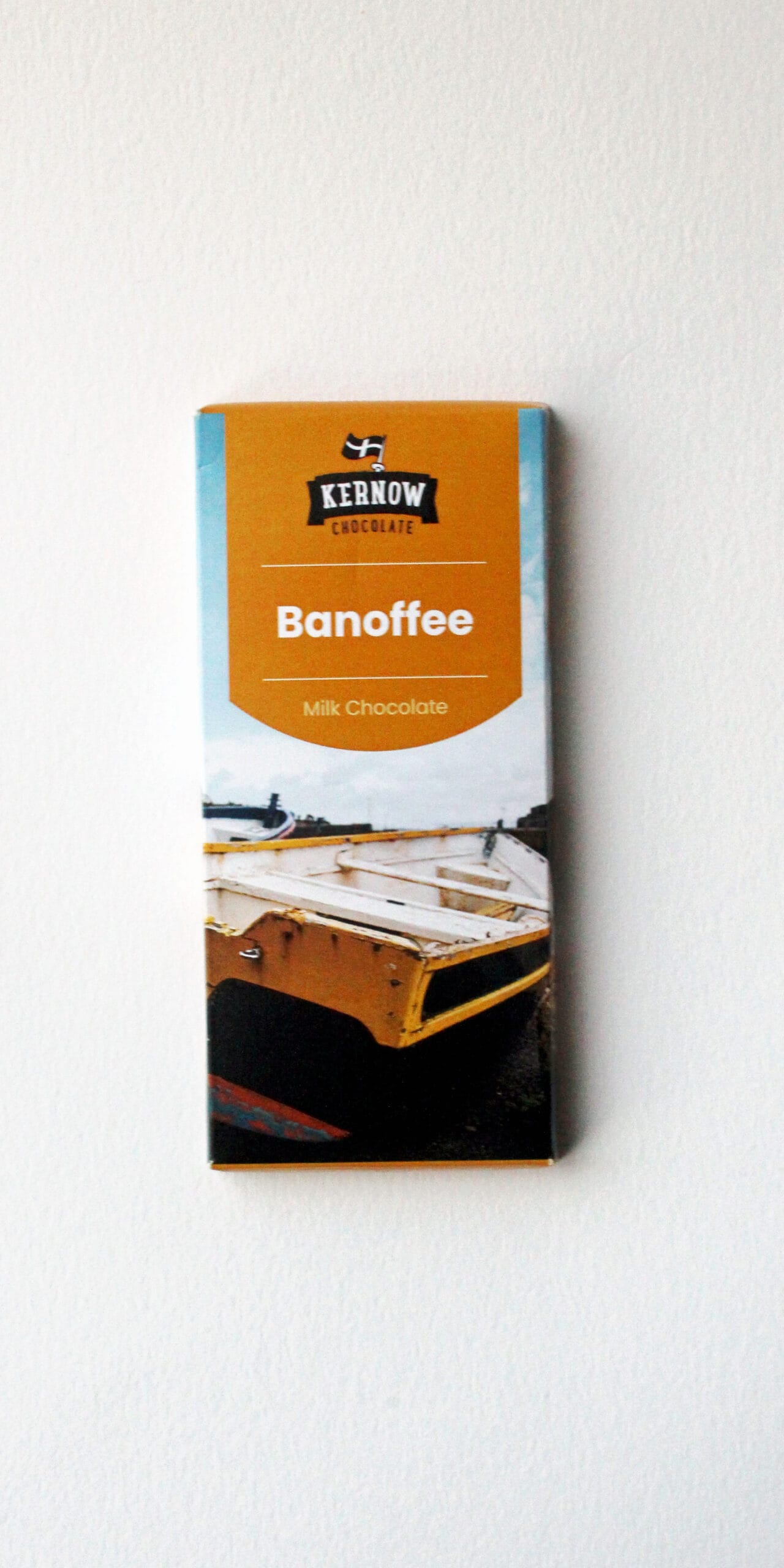 Banoffee Kernow Chocolate milk chocolate bar featuring an orange label with Kernow branding and a coastal boat image against a pale blue sky.